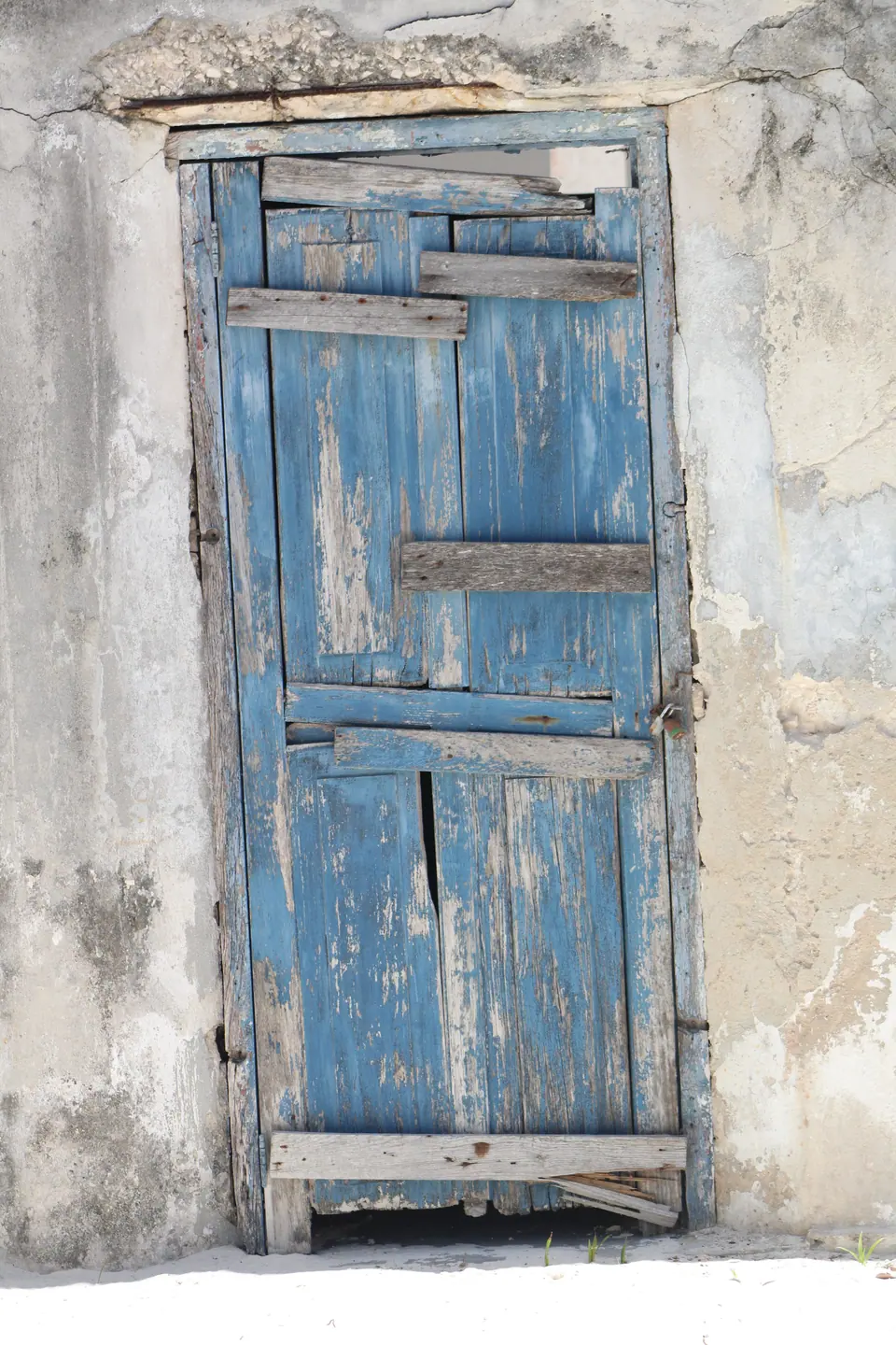 Puerta azul antigua de madera en una pared de la isla
